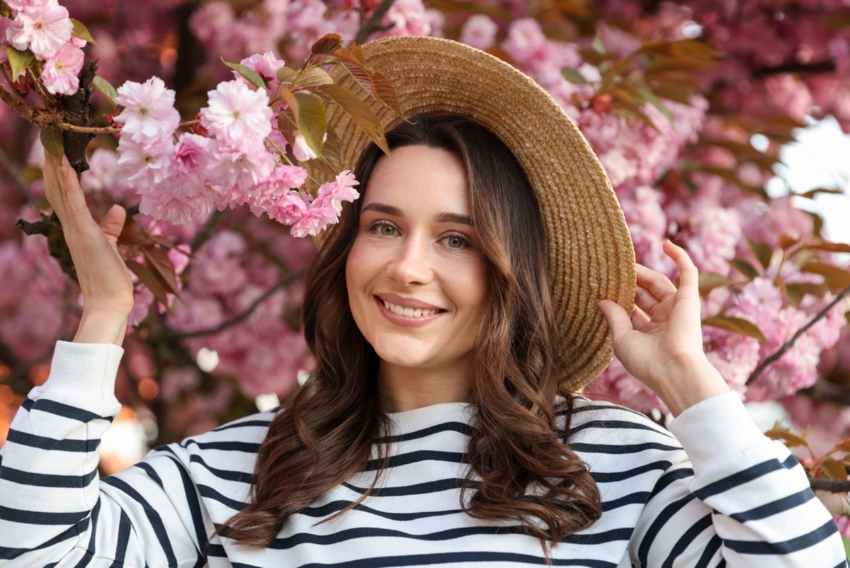 Lächelnde Frau mit Blumen im Hintergrund | Luminar Blog