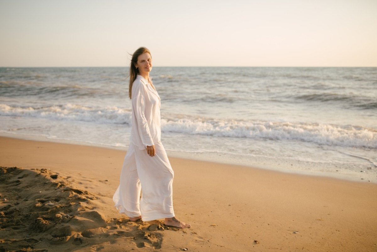 Frau im weißen Kleid am Strand bei Sonnenuntergang | Luminar Blog