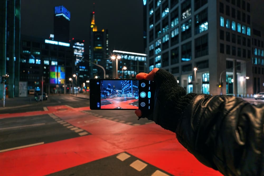 Mann macht eine Langzeitbelichtung mit seinem Handy in der Stadt | Luminar Neo Blog 