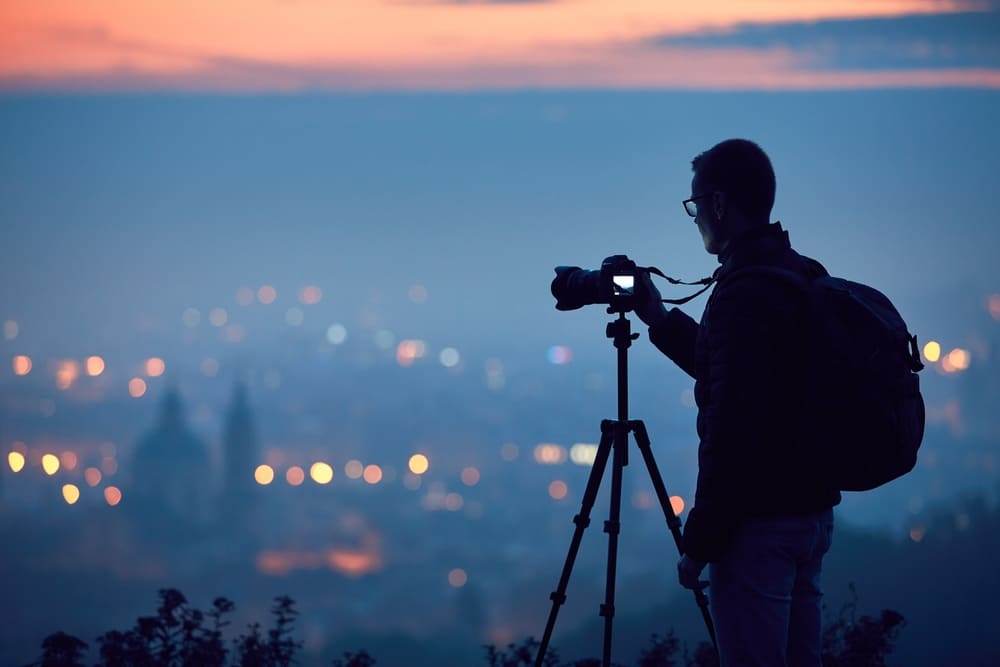 Ein Fotograf fotografiert eine Stadt bei Nacht | Luminar Neo Blog 