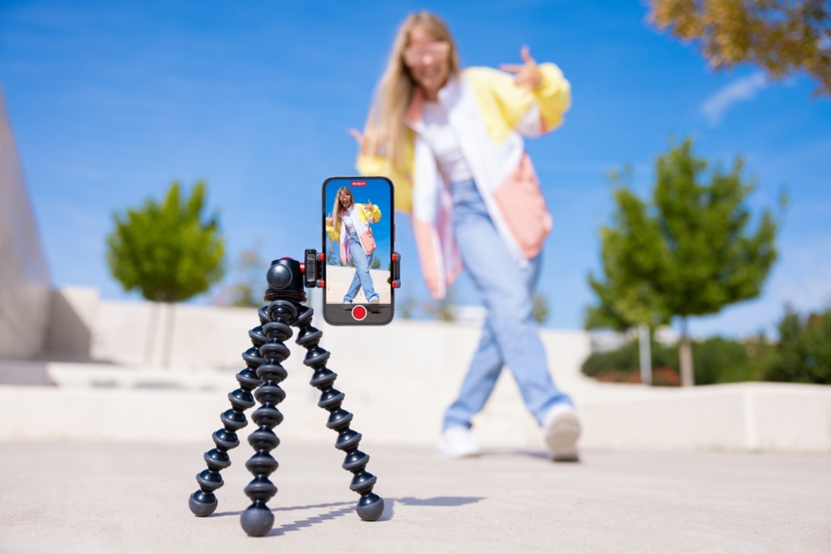 Mädchen dreht Video auf Handy mit Stativ | Luminar Neo Blog 

