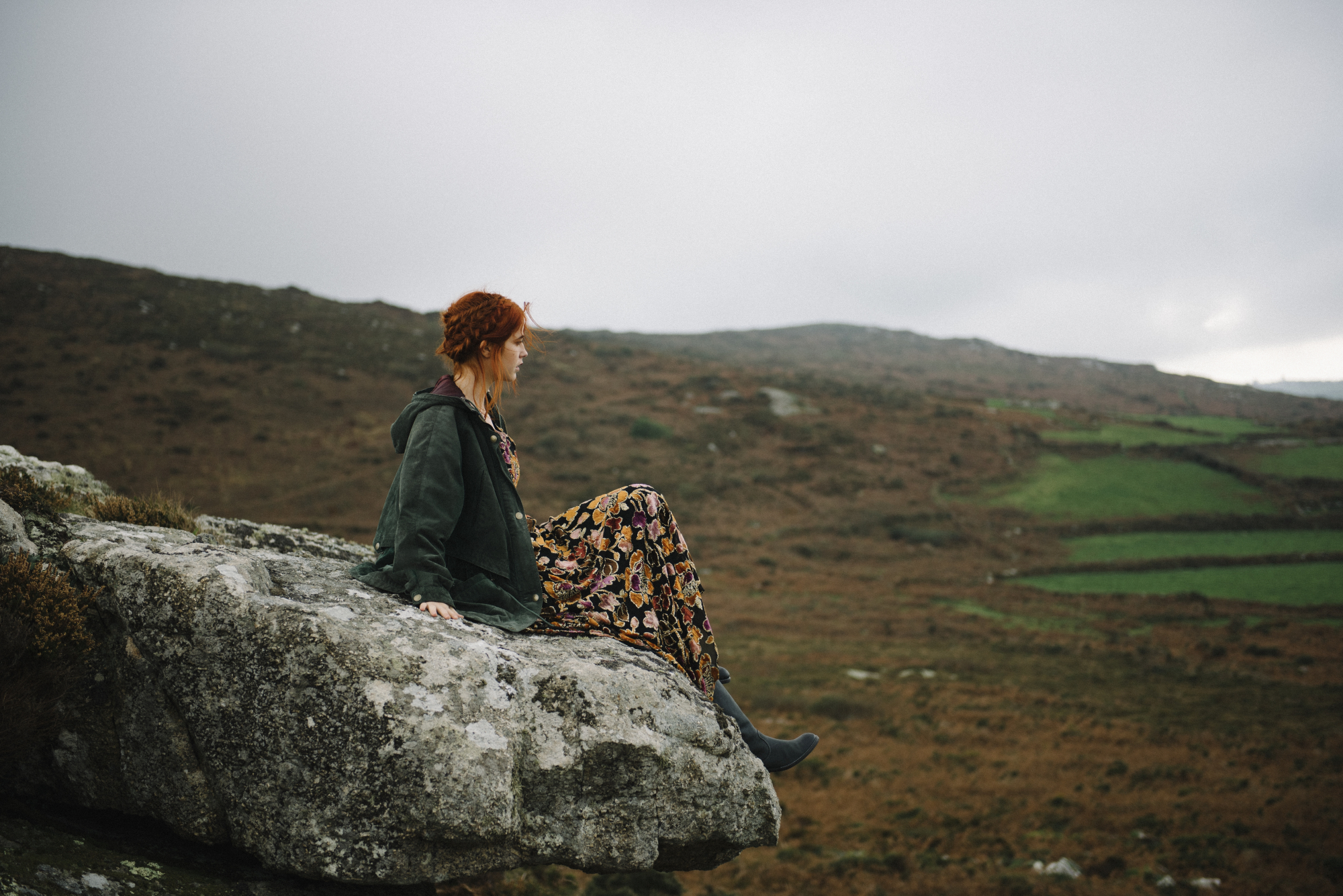 a woman sitting on a rock