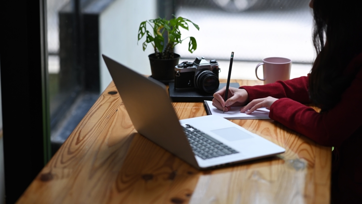 Ein Fotograf macht sich Notizen in einem Notizbuch | Luminar Neo Blog

