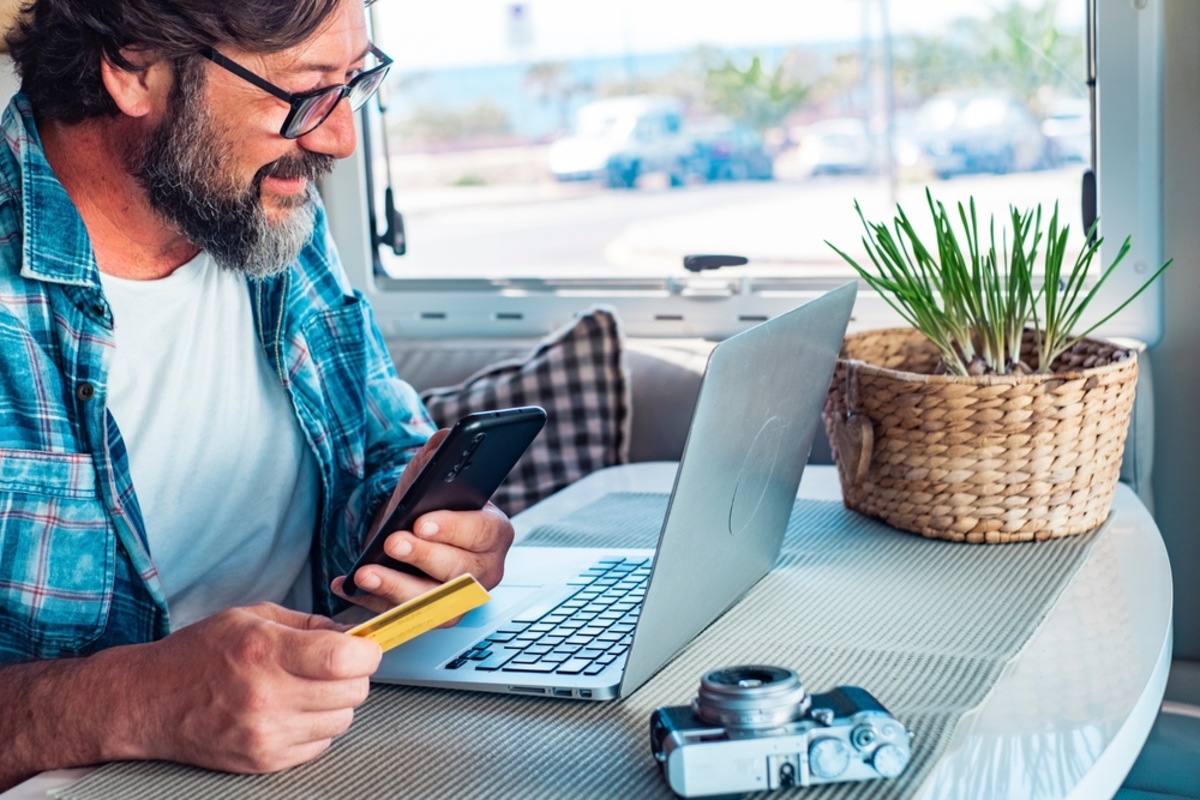 Fotograf mit Kreditkarte vor Laptop | Luminar Neo Blog