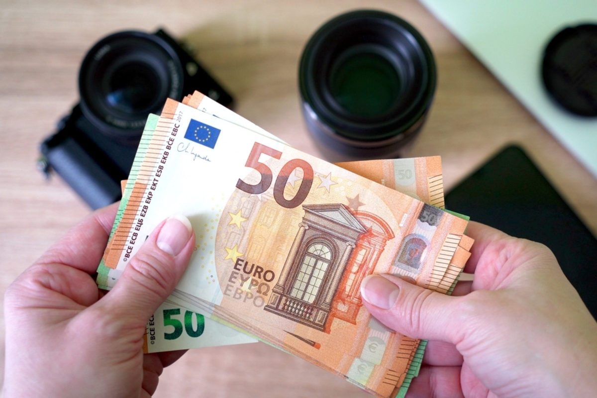 Der Fotograf hält Geld in seinen Händen | Luminar Neo Blog