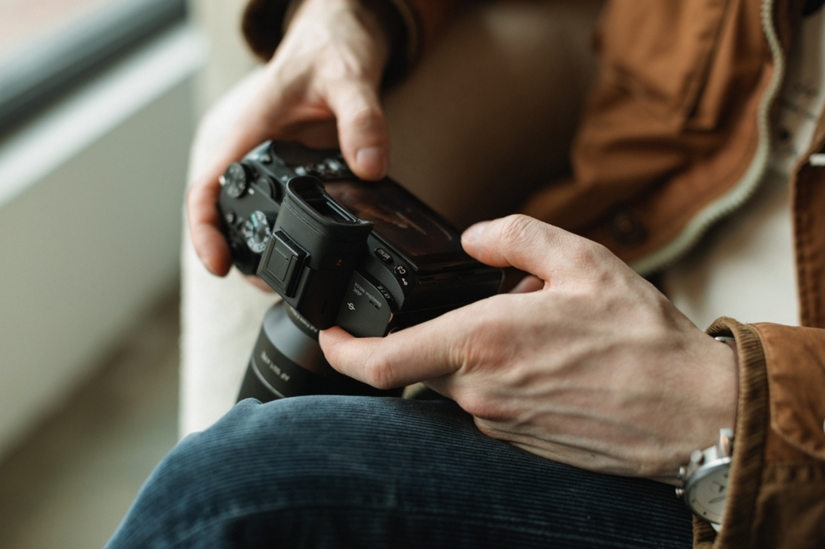 Ein Fotograf mit einer Kamera in den Händen | Luminar Neo  Blog

