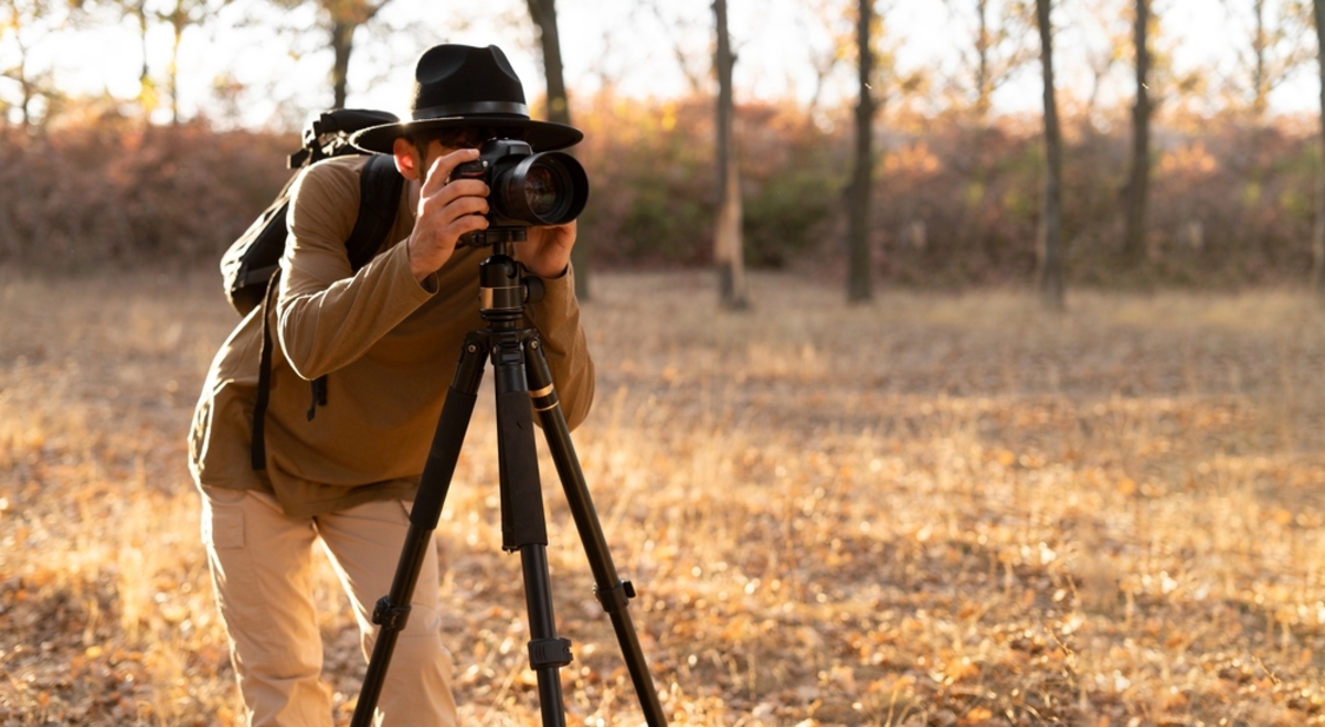 Ein Fotograf mit einer Kamera auf einem Stativ | Luminar Neo  Blog

