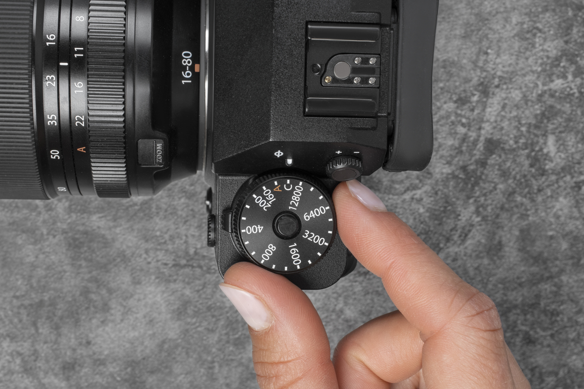 Ein Mann stellt den ISO-Wert einer Kamera manuell ein | Luminar Neo Blog