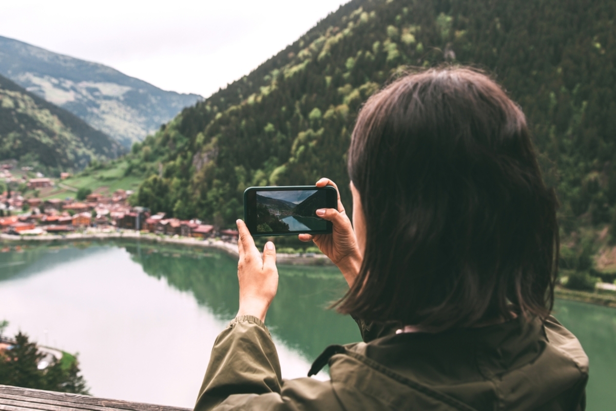 Ein Mädchen fotografiert die Natur mit einem Smartphone | Luminar Neo Blog