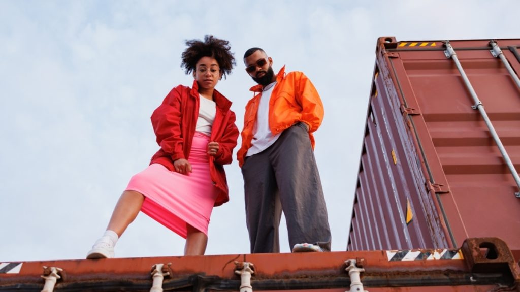 Froschperspektive auf zwei Personen vor Containern | Luminar Neo Blog