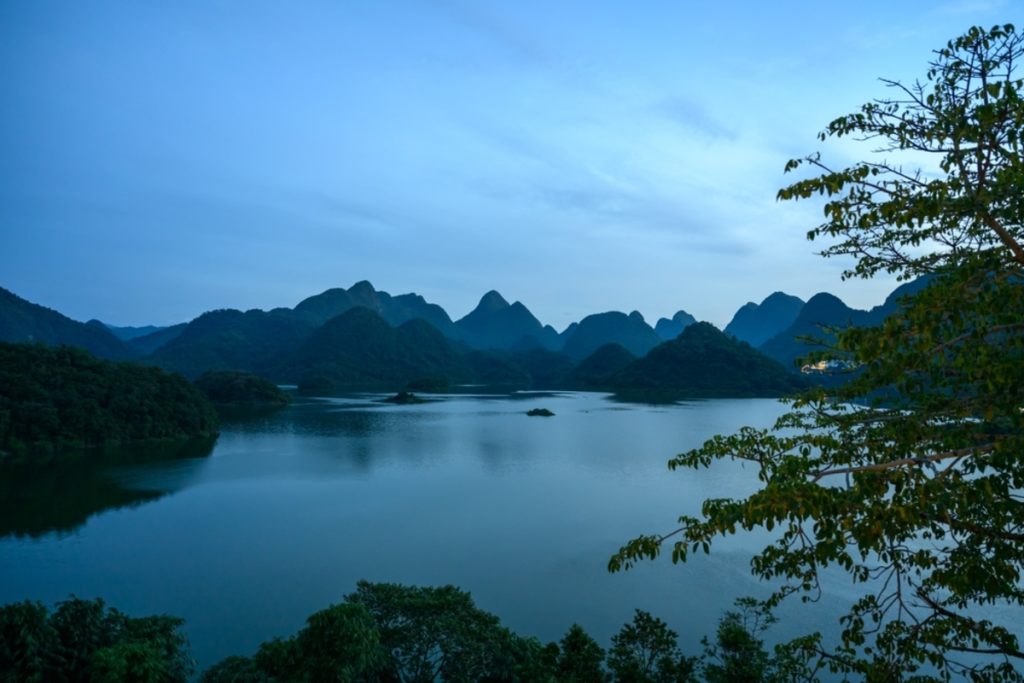 Landschaftsaufnahme mit Bergen und See bei Dämmerung | Luminar Neo Blog