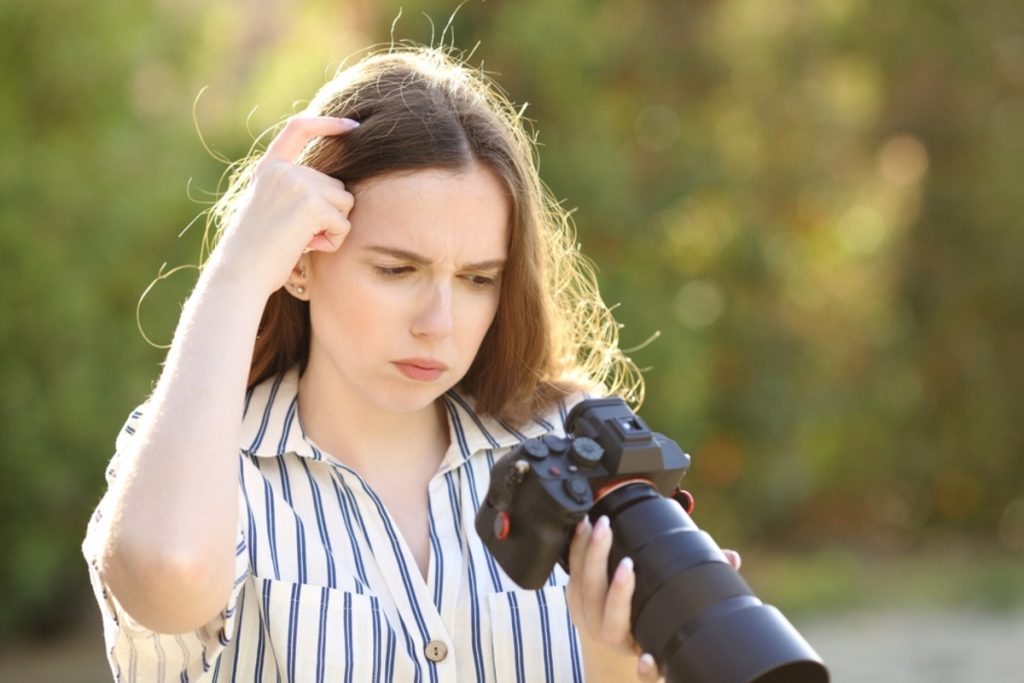 Ratlose Fotografin mit Kamera bei der Fehlersuche | Luminar Neo Blog