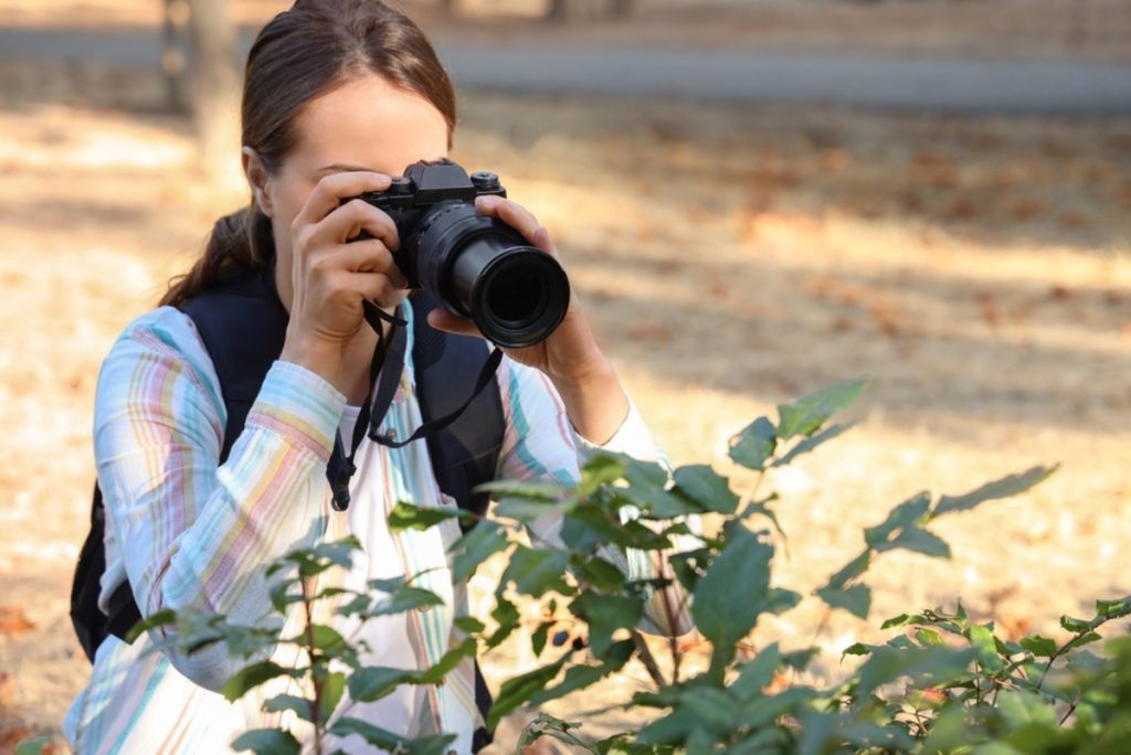 Fotografin fotografiert vorsichtig in der Natur | Luminar Neo Blog