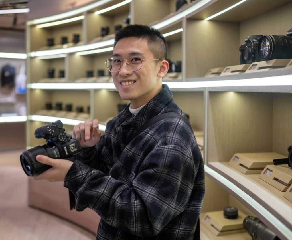 Ein Fotograf wählt in einem Geschäft eine Kamera aus | Luminar Neo Blog