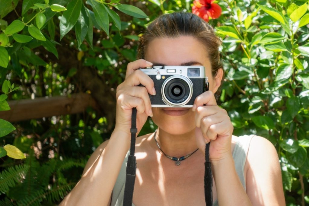 Ein Mädchen hält eine Kompaktkamera in ihren Händen | Luminar Neo Blog