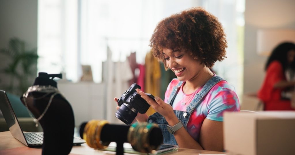 Frau mit lockigem Haar arbeitet am Schreibtisch | Luminar Neo Blog