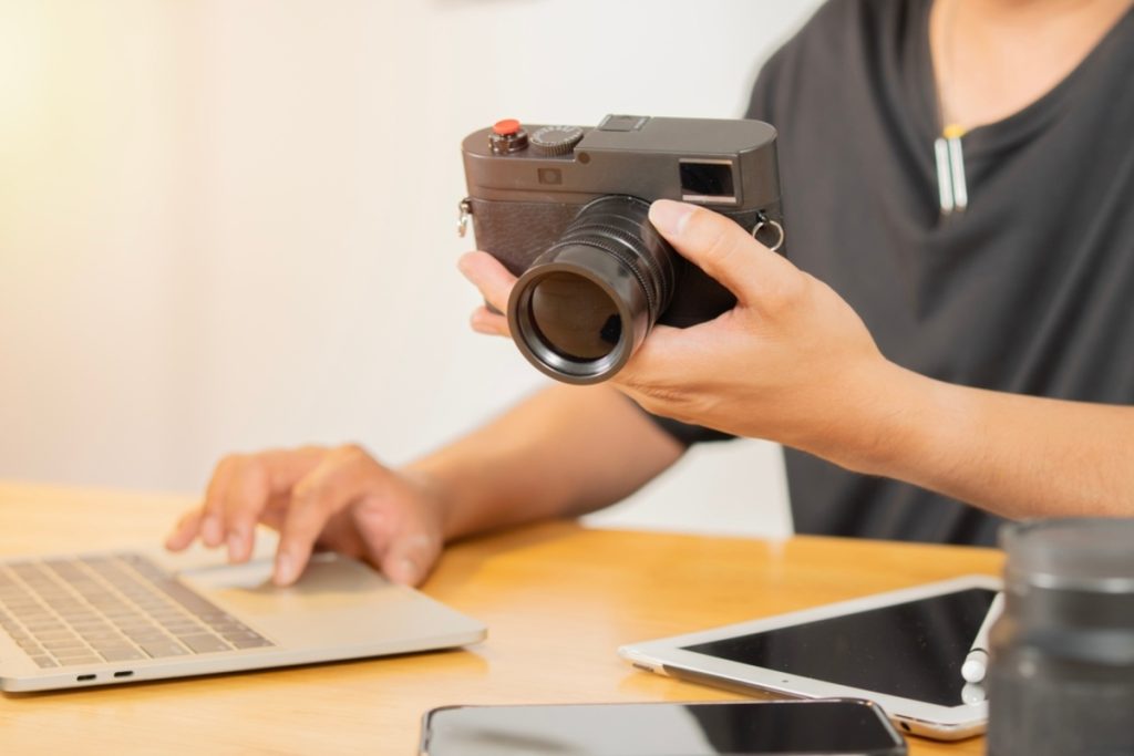 Ein Mann hält eine Kompaktkamera in den Händen | Luminar Neo Blog