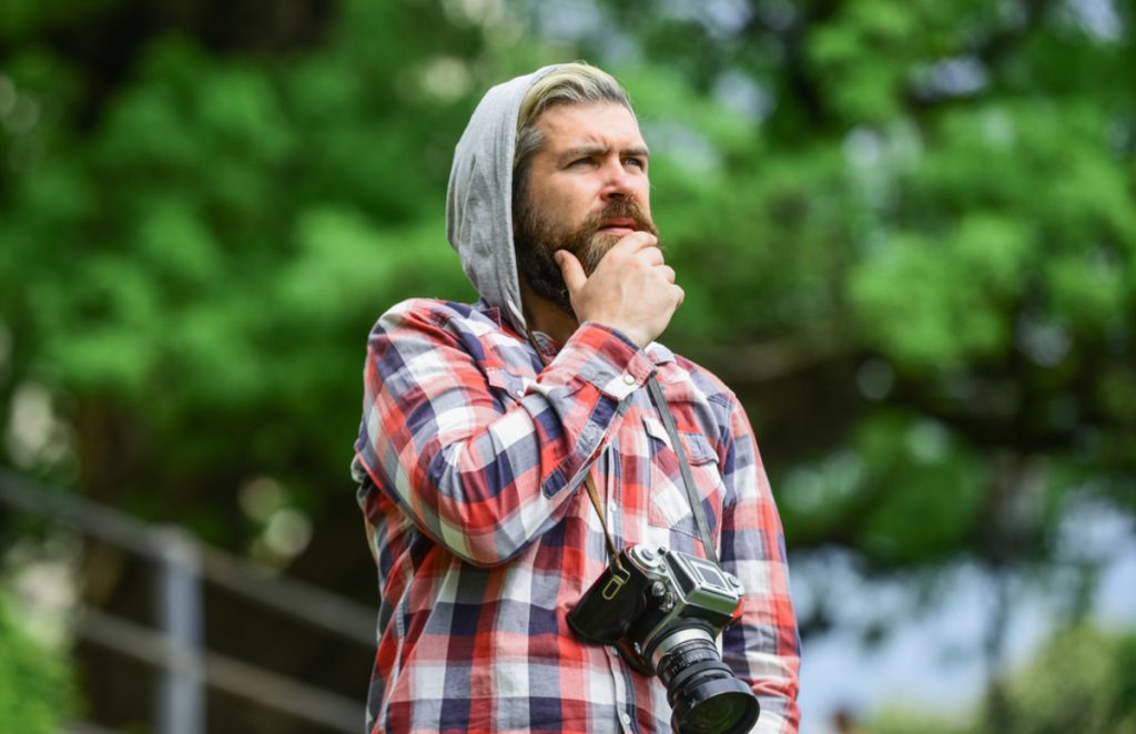 Ein Fotograf mit einer Kamera sinniert | Luminar Neo Blog