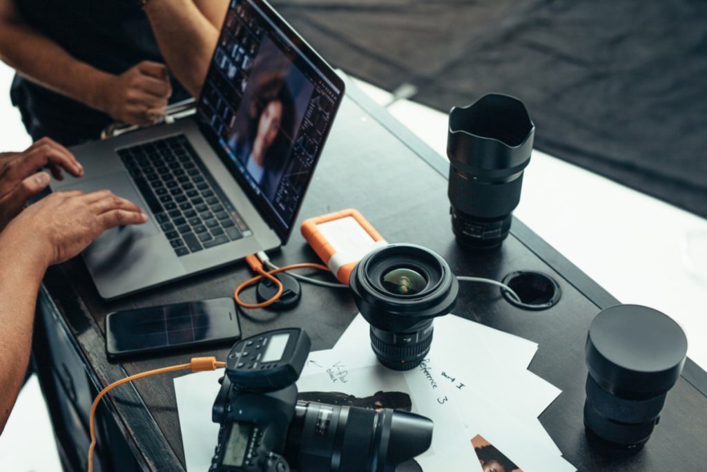 Fotozubehör und ein Laptop auf einem Tisch | Luminar Blog