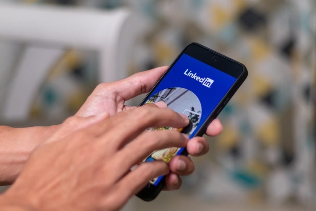 Person bedient LinkedIn-App auf dem Smartphone | Luminar Blog
